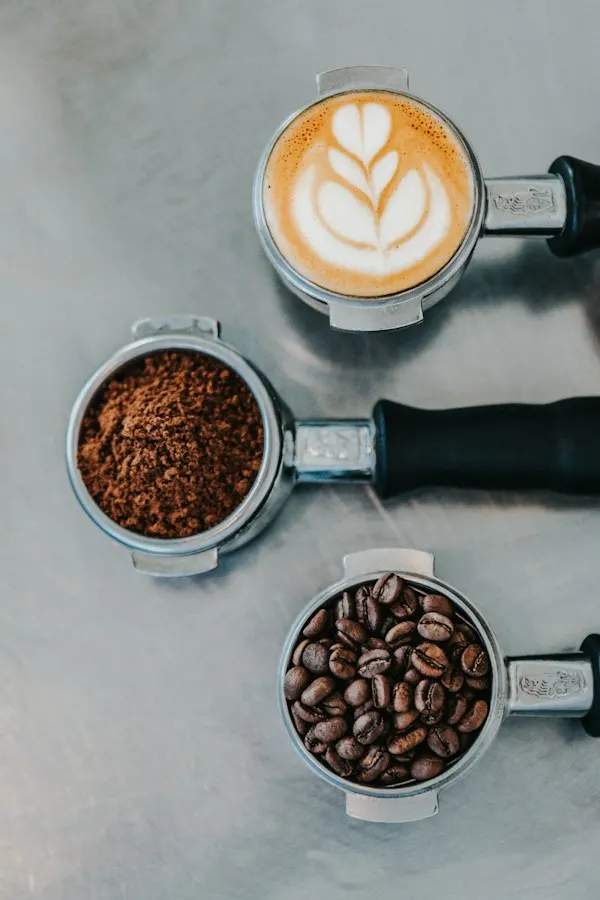 A portafilter of fresh grounds beside an espresso